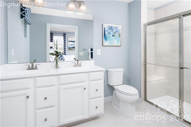 559 Grandiflora Avenue, Unit 108 Lancaster, SC 29720 - Photo 7 of 10 a bathroom with a toilet a sink and mirror