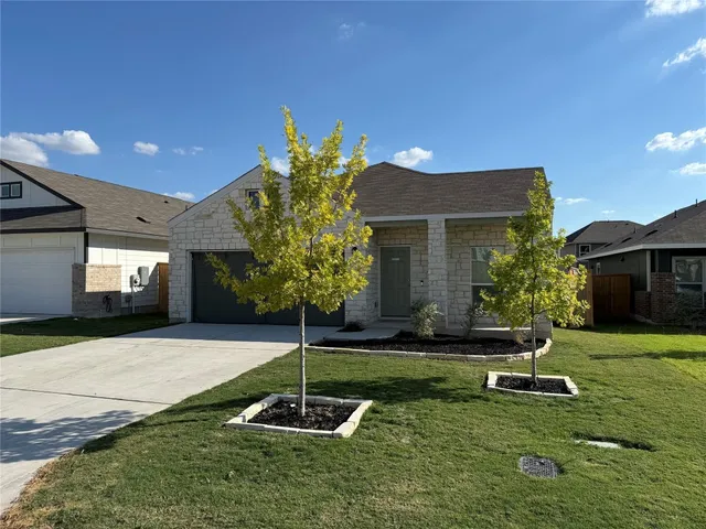a front view of a house with a yard garage and outdoor seating