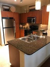 a kitchen with granite countertop a sink a stove and a refrigerator