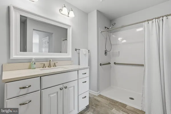 a bathroom with a shower sink and mirror