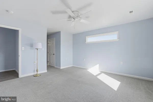 an empty room with a ceiling fan and a window