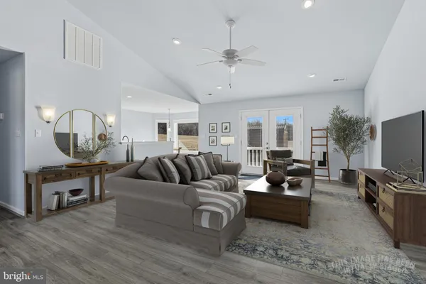 a living room with furniture flat screen tv and kitchen view