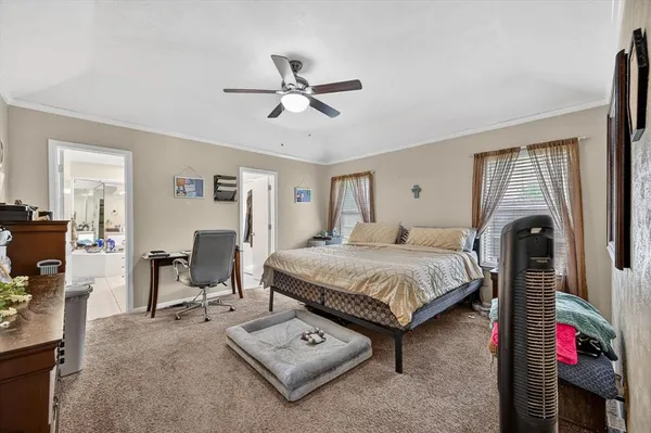 a spacious bedroom with a bed a couch and a chandelier