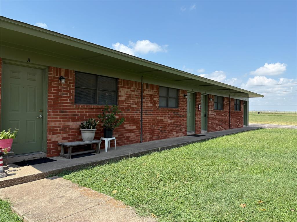 1708 Short Street, Unit B Cleburne, TX 76033 - Photo 7 of 8 Brick exterior building with a green fascia and flat roofline