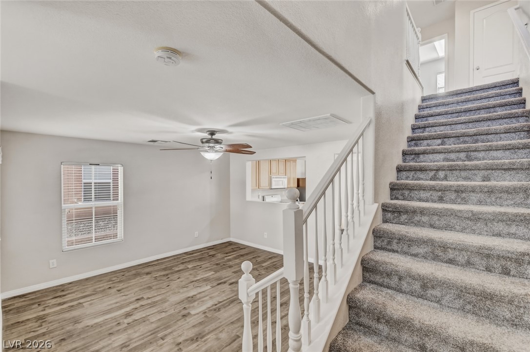 11159 Ranch Valley Street Las Vegas, NV 89179 - Photo 11 of 27 A well-lit interior space with a blend of resilient flooring and carpeted stairs, creating a welcoming flow.