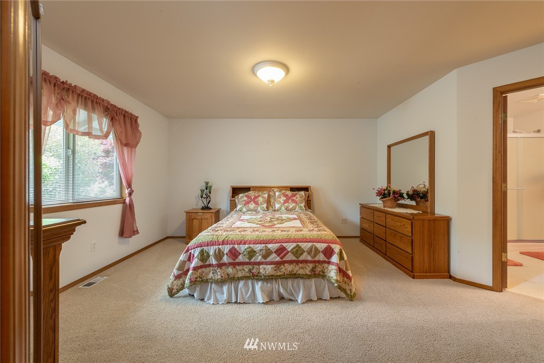 5203 53rd Street West University Place, WA 98467 - Photo 15 of 35 a bedroom with a bed and a dresser next to a window