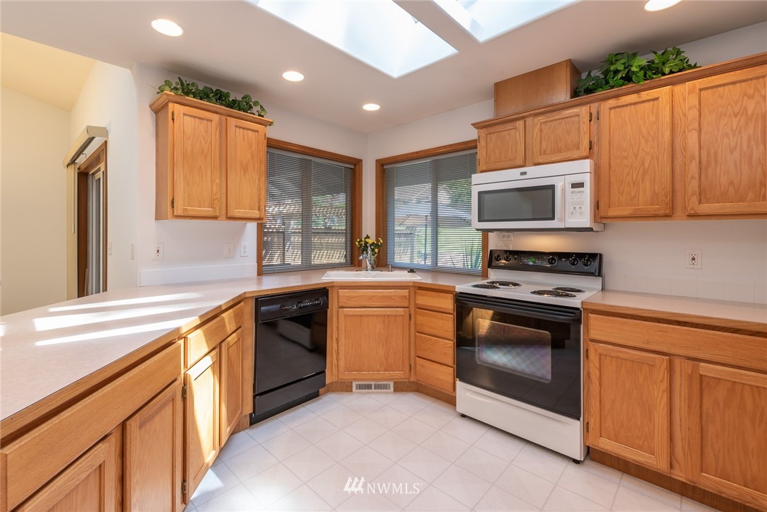 5203 53rd Street West University Place, WA 98467 - Photo 10 of 35 a kitchen with stainless steel appliances granite countertop a stove a sink and a microwave