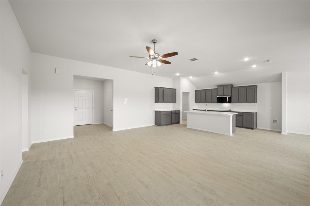 1184 Oak Spring Drive Burleson, TX 76028 - Photo 11 of 27 a view of a kitchen with a sink a kitchen island and stainless steel appliances
