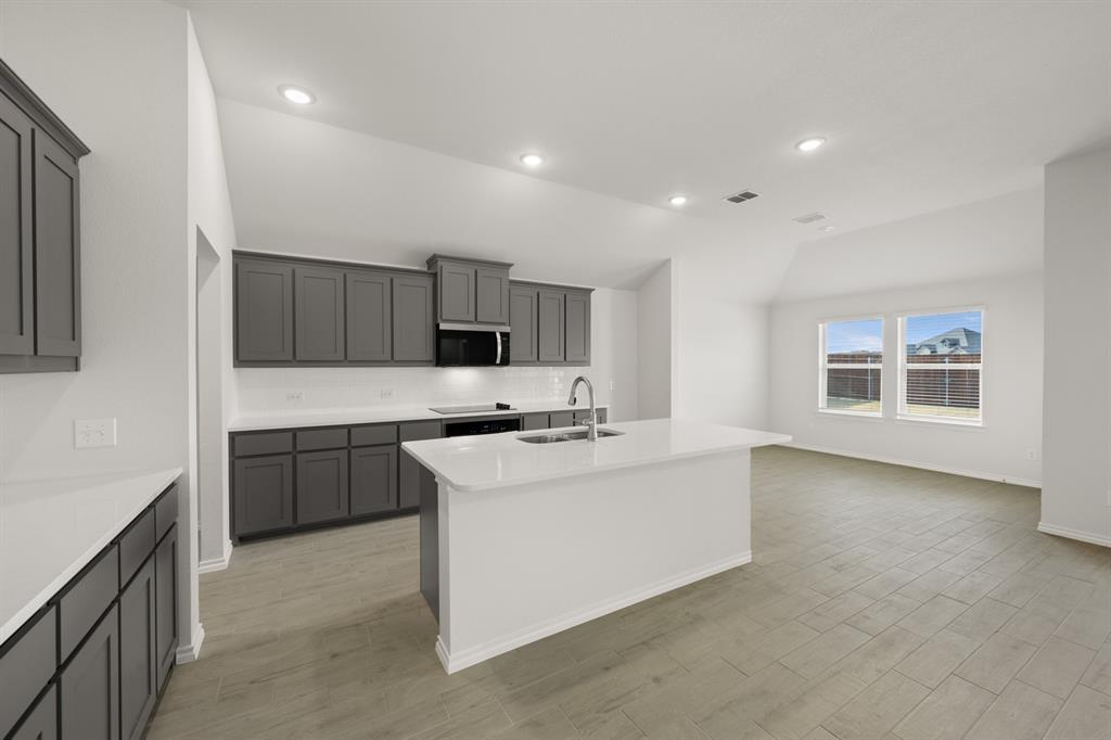 1184 Oak Spring Drive Burleson, TX 76028 - Photo 6 of 27 a kitchen with stainless steel appliances a sink stove and cabinets