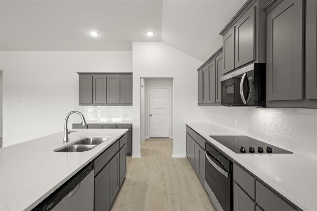 1184 Oak Spring Drive Burleson, TX 76028 - Photo 7 of 27 a kitchen with granite countertop a sink stove and refrigerator