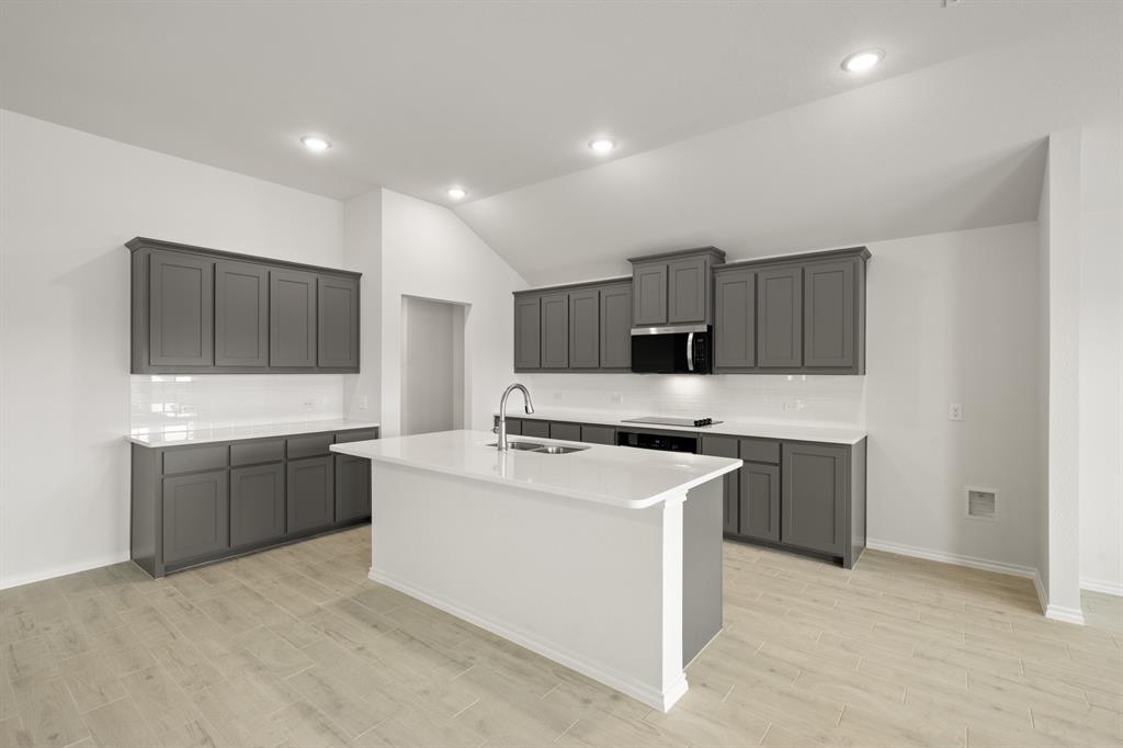 1184 Oak Spring Drive Burleson, TX 76028 - Photo 9 of 27 a kitchen with sink a stove and cabinets