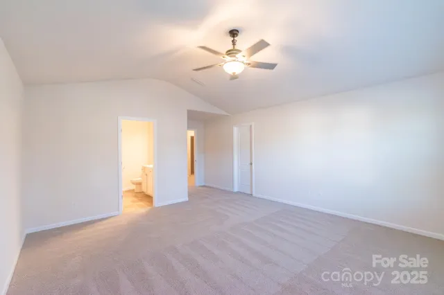 a view of an empty room with a chandelier fan