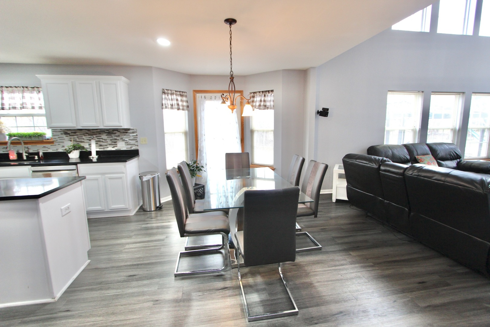 1458 Wildmeadow Road Round Lake, IL 60073 - Photo 12 of 45 a kitchen with granite countertop a dining table chairs and a wooden floor