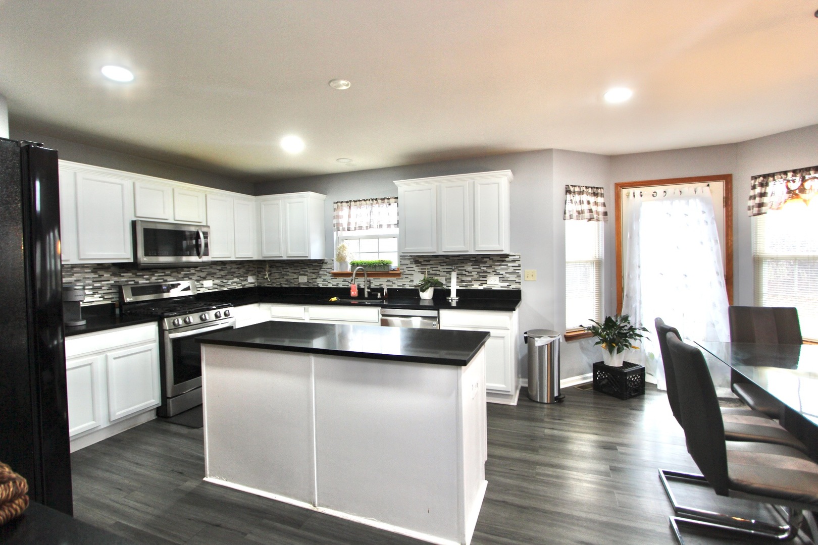 1458 Wildmeadow Road Round Lake, IL 60073 - Photo 15 of 45 a kitchen with stainless steel appliances granite countertop a stove top oven a sink dishwasher a refrigerator and white cabinets with wooden floor