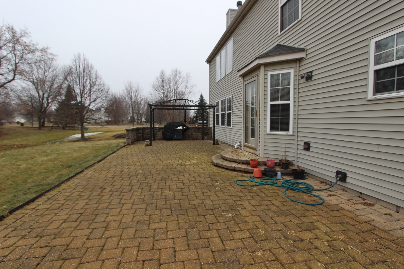 1458 Wildmeadow Road Round Lake, IL 60073 - Photo 44 of 45 a backyard of a house with barbeque oven table and chairs
