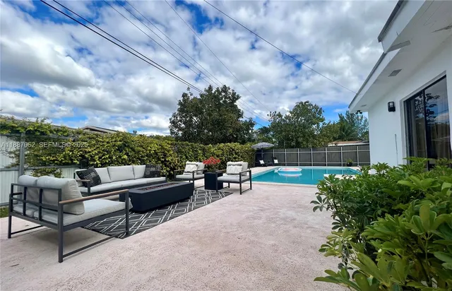a view of a patio with table and chairs under an umbrella