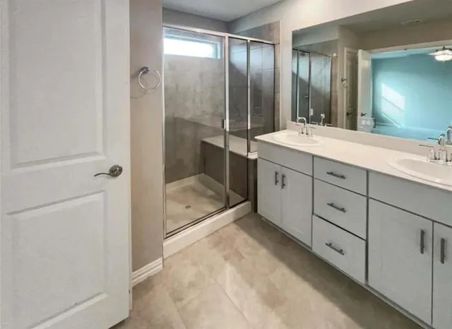 a bathroom with a double vanity sink toilet and shower