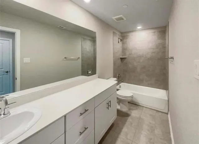 a spacious bathroom with a granite countertop sink a toilet and shower
