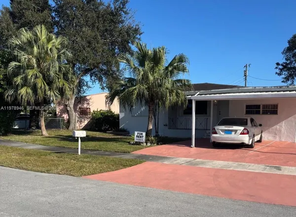 a view of a house with entertaining space and a car parked in front of it