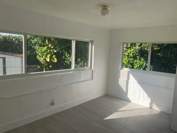 a room with a window and a projector screen