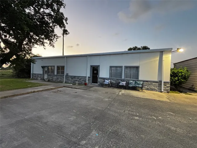 a view of a house with a backyard and a tree