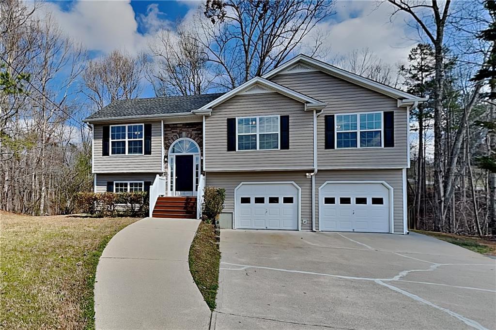 a front view of a house with large trees