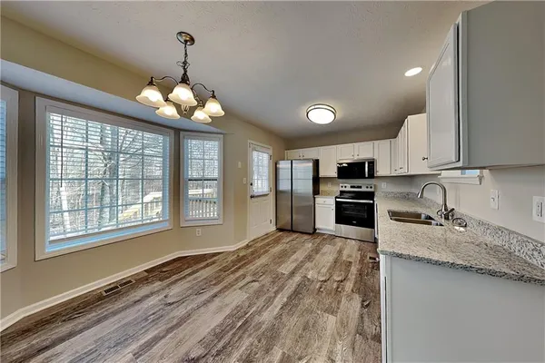 a large kitchen with kitchen island granite countertop a stove a sink and dishwasher a oven with wooden cabinets