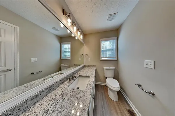 a bathroom with a toilet sink and mirror