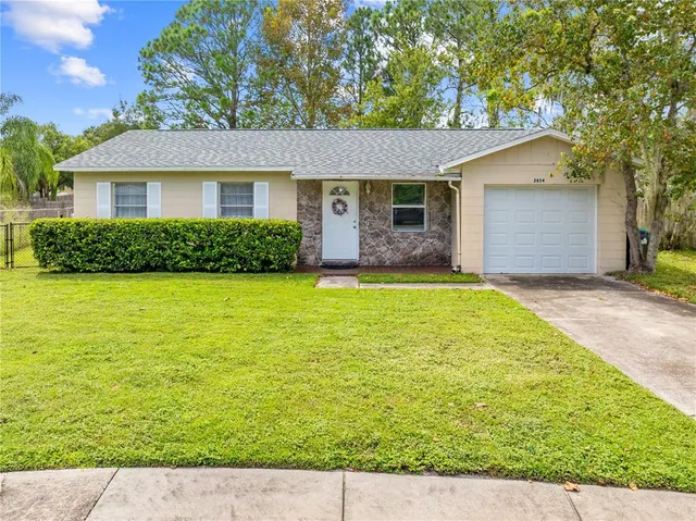a view of a house with a yard and potted plants