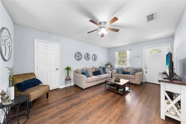 a living room with furniture and wooden floor
