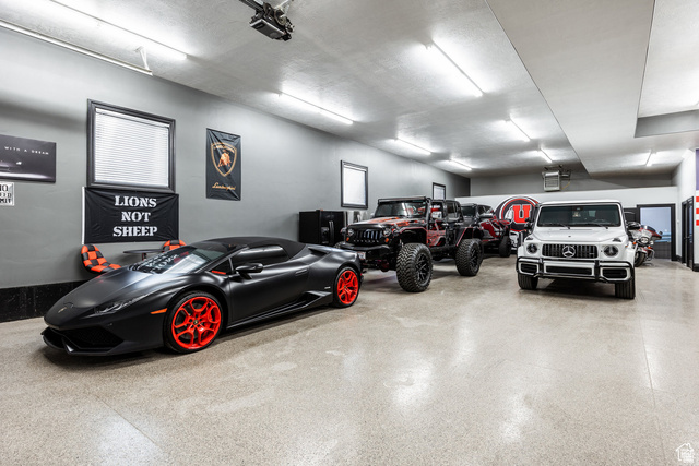 694 West Cephus Road Draper, UT 84020 - Photo 109 of 148 Spacious garage featuring ample vehicle storage, fluorescent lighting, a durable epoxy floor, multiple windows, and a built-in air conditioning unit