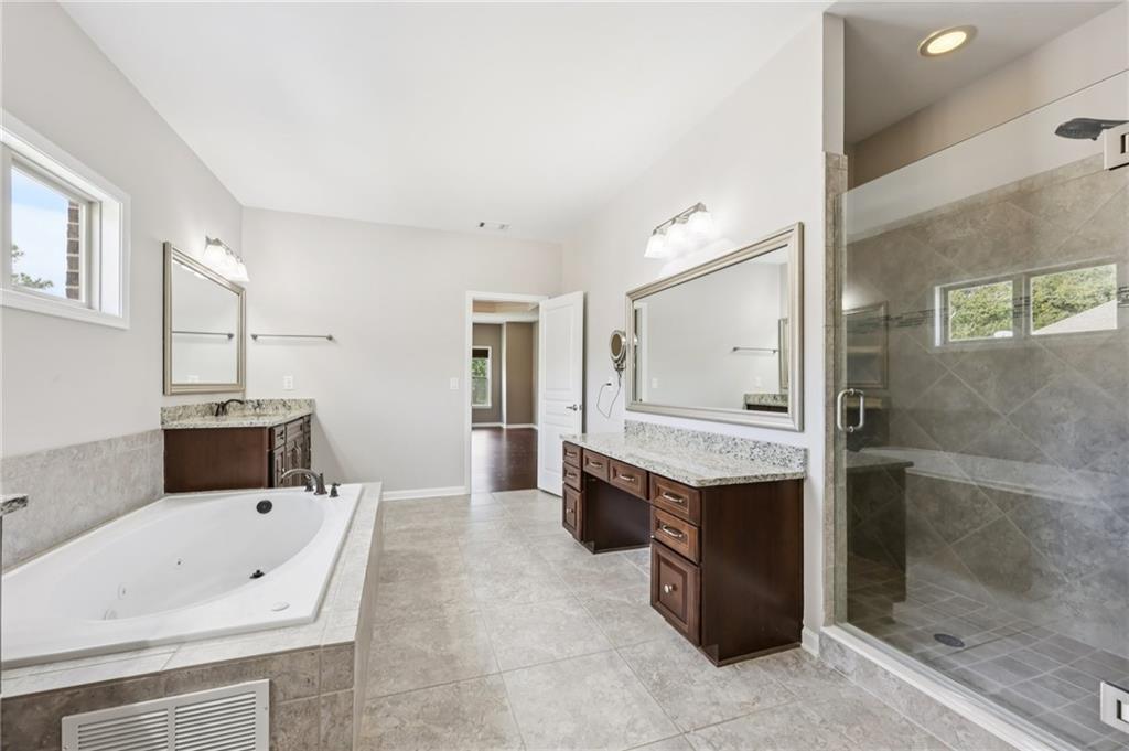 3328 Knight Road Marietta, GA 30066 - Photo 15 of 44 a spacious bathroom with a tub sink and mirror