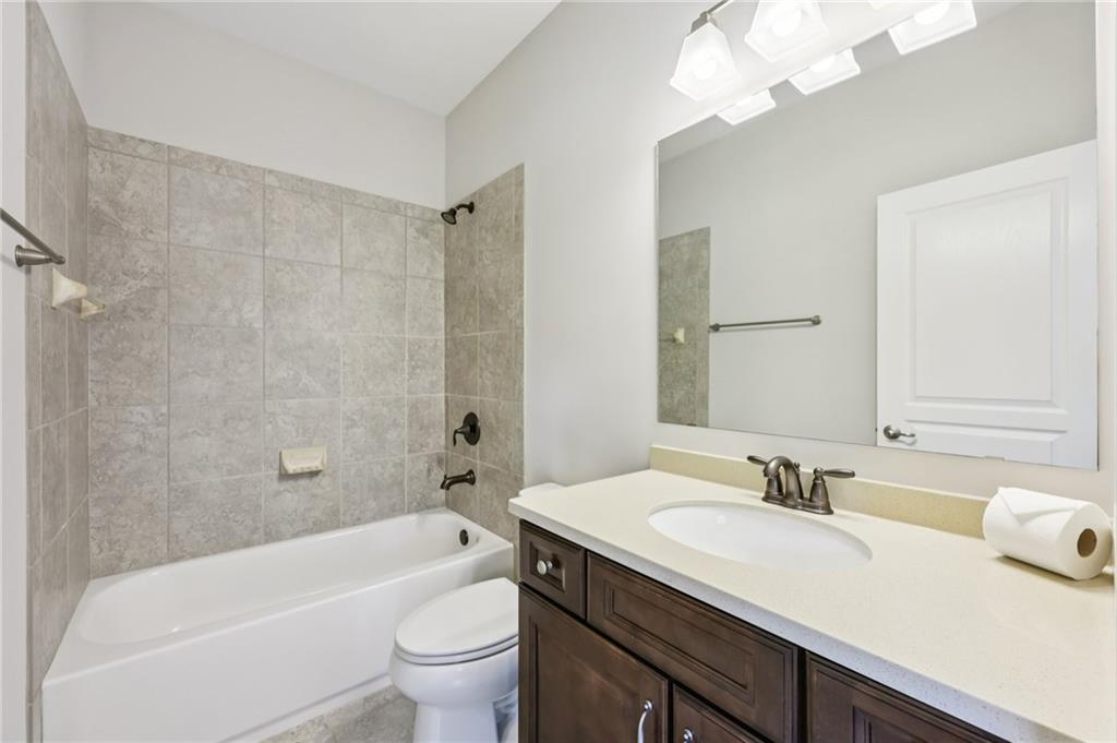 3328 Knight Road Marietta, GA 30066 - Photo 20 of 44 a bathroom with a sink a toilet a mirror a bathtub and shower
