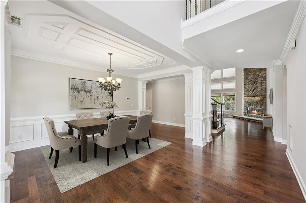 3328 Knight Road Marietta, GA 30066 - Photo 2 of 44 a dining room with wooden floor a chandelier a wooden table and chairs