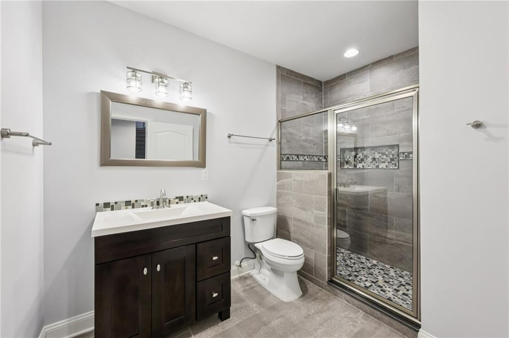 3328 Knight Road Marietta, GA 30066 - Photo 26 of 44 a bathroom with a double vanity sink toilet mirror and shower