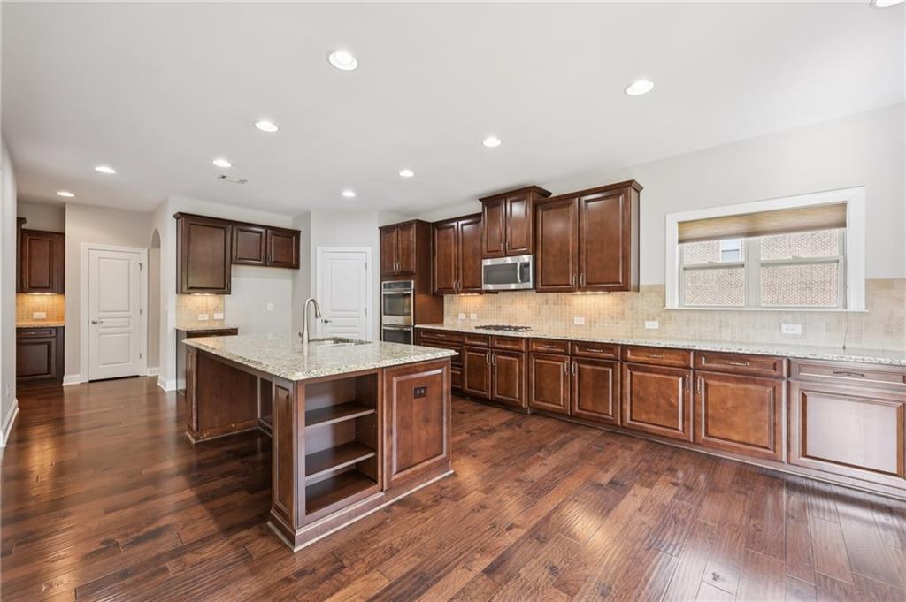 3328 Knight Road Marietta, GA 30066 - Photo 9 of 44 a large kitchen with stainless steel appliances granite countertop a large center island and a wooden floors