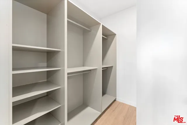 a view of walk in closet with empty racks