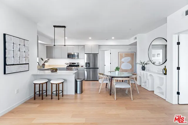 a living room with stainless steel appliances kitchen island granite countertop furniture and a dining table with kitchen view