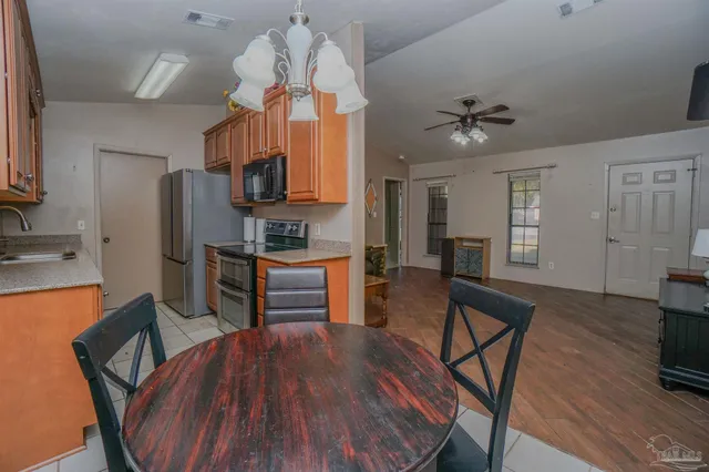 a kitchen with stainless steel appliances granite countertop a sink a stove counter space and cabinets