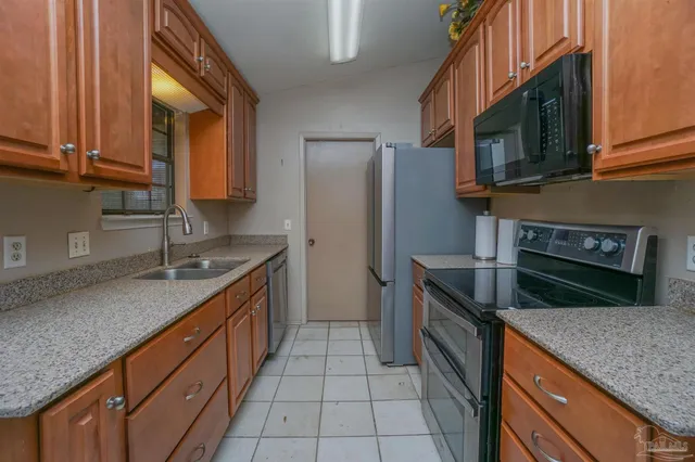 a kitchen with stainless steel appliances granite countertop a sink stove and cabinets