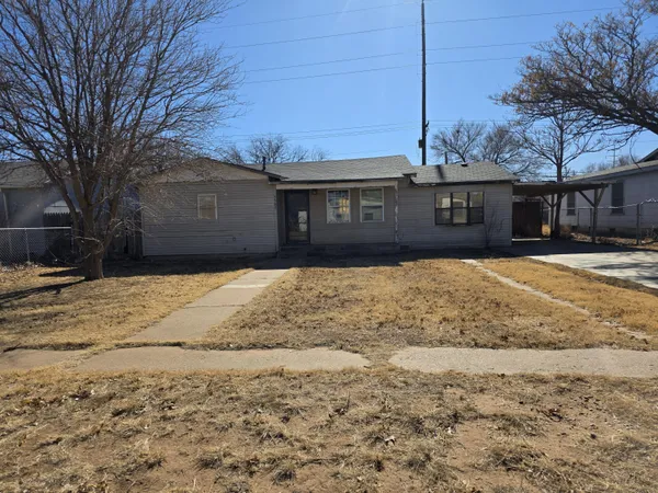 a front view of house with yard and trees around