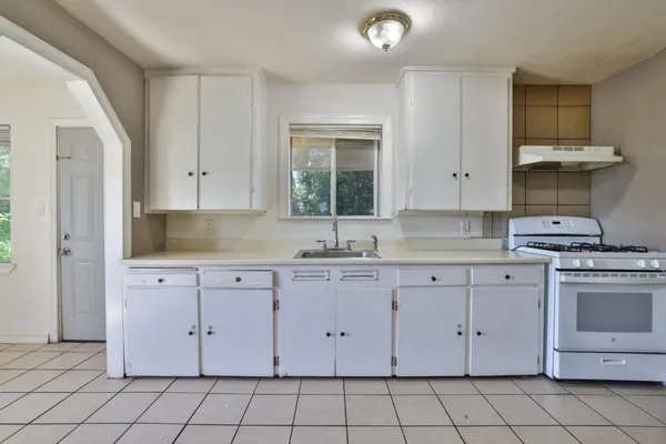 a kitchen with white cabinets stainless steel appliances