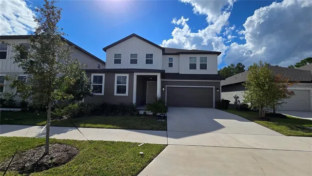 a front view of a house with a garden and yard