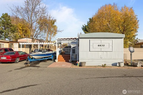 a view of a house with car parked on the road