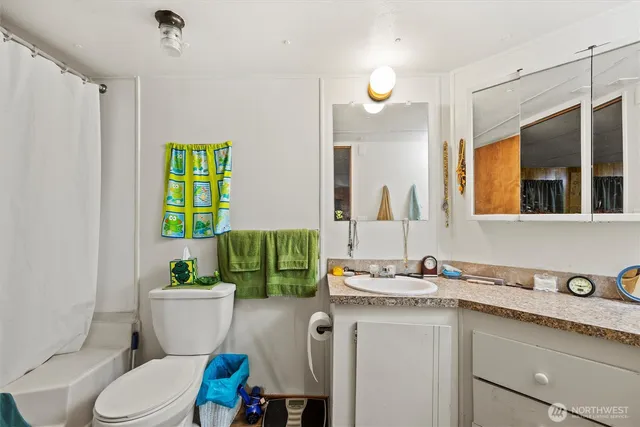 a bathroom with a granite countertop toilet sink and mirror