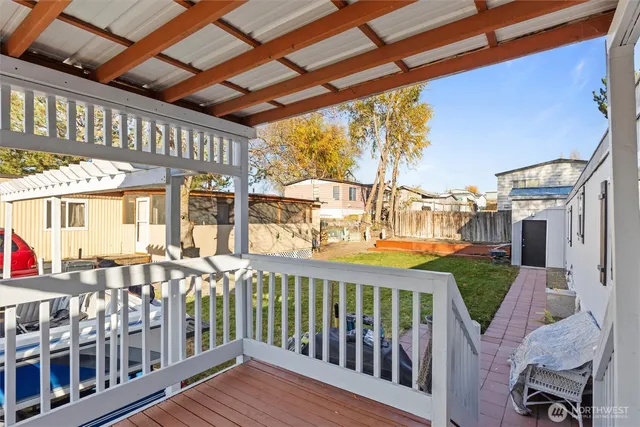 a view of a porch with wooden floor and roof with a garden view
