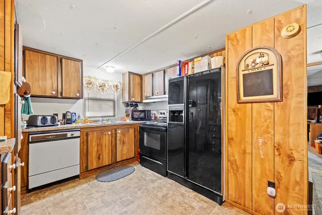 a kitchen with stainless steel appliances granite countertop a refrigerator and a stove top oven