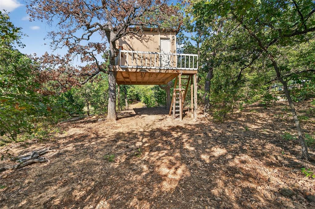 10312 Arvin Hill Road Aubrey, TX 76227 - Photo 11 of 40 a view of a wooden house with large trees