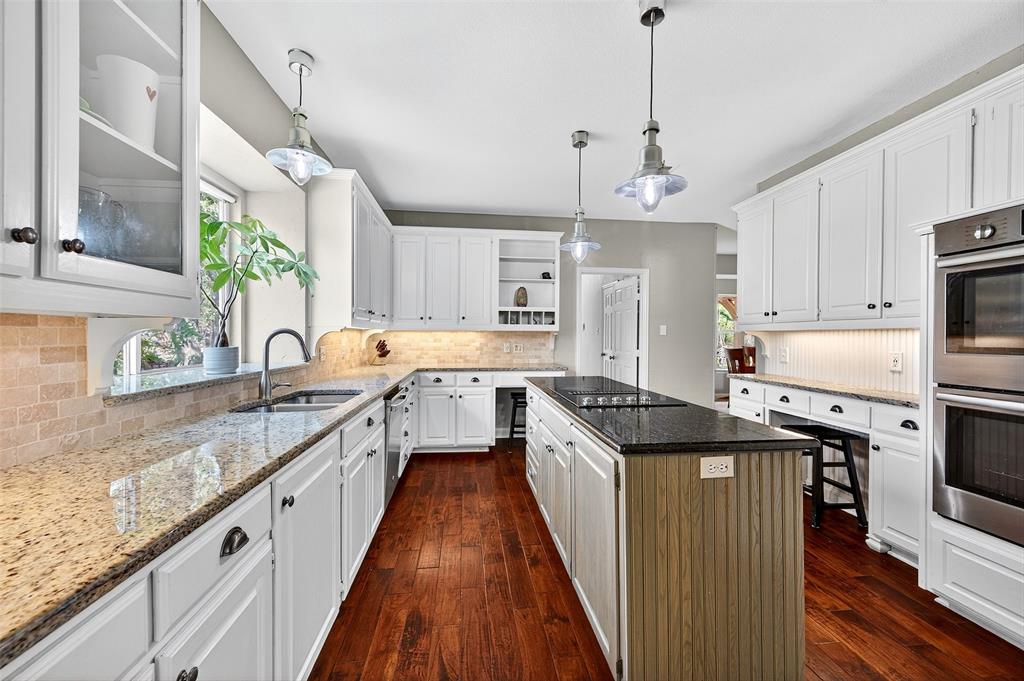10312 Arvin Hill Road Aubrey, TX 76227 - Photo 15 of 40 a kitchen with granite countertop kitchen island stainless steel appliances a sink stove and refrigerator