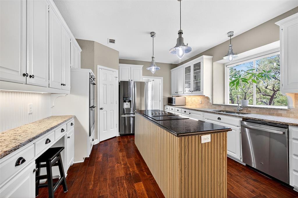 10312 Arvin Hill Road Aubrey, TX 76227 - Photo 16 of 40 a kitchen with stainless steel appliances granite countertop a stove a refrigerator a sink and white cabinets